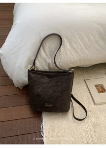 Nahaufnahme einer Vintage-Eimertasche aus dunkelbraunem Leder mit goldener Schnalle