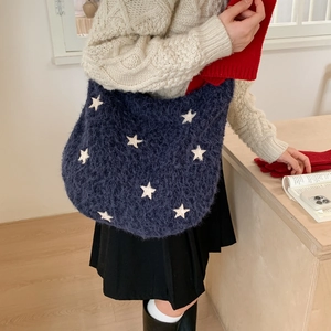 Macro detail of navy blue plush star bag with soft knit texture and winter aesthetic