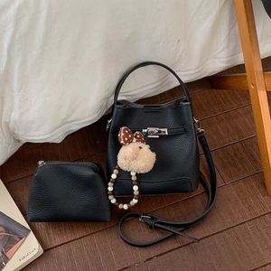 Close-up of black lychee texture leather bucket bag set with silver buckle and dog charm