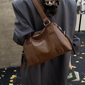 Detail of dark brown vintage Boston bag showing PU leather texture and adjustable strap