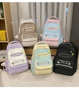 Five assorted colorful school backpacks in nylon material with cute cartoon pendants
