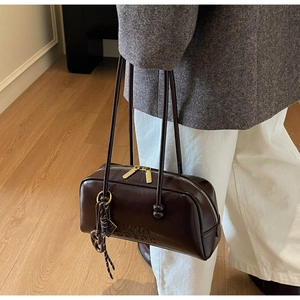 Close-up of vintage dark brown bowling bag with glossy patent finish and long straps