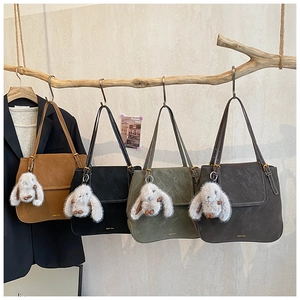 Détail de sacs seaux vintage en quatre couleurs avec pendentif en peluche lapin mignon