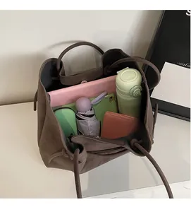 Top view of large capacity vintage brown suede tote bag showing daily essentials inside