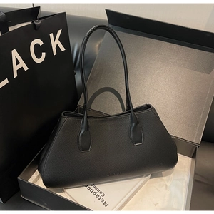 Close-up of black lychee grain leather tote bag inside a premium black branded gift box