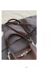 Détail du sac marron foncé à grain litchi avec poignée tressée et fermoir pivotant
