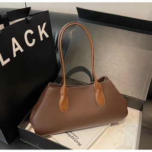 Detail of dark brown lychee texture leather tote bag with elegant trapezoid design