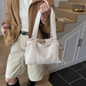 Macro shot of cream Boston bag texture featuring smooth PU leather and metal zipper detail