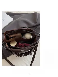 Vue intérieure détaillée du sac seau marron montrant les compartiments et le rangement