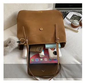 Vue de dessus du sac seau spacieux en cuir marron montrant l'intérieur avec la tablette