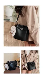 Détail du sac seau noir en cuir grainé avec fermoir rotatif argenté et breloque lapin en peluche