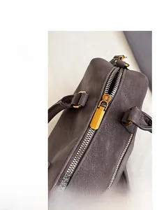 Detailed macro shot of premium golden metal zipper on brown pebble leather bag