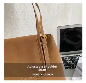 Détail de la bandoulière réglable avec boucle dorée et surpiqûres sur sac marron
