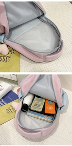 Detail view of pink and blue school backpack interior capacity with books and water bottle