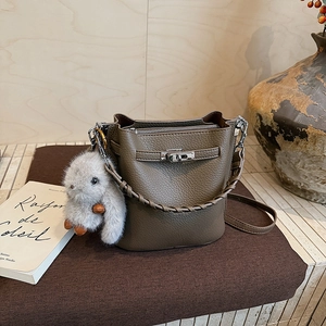 Détail du sac seau marron foncé avec texture grainée et fermoir pivotant en argent