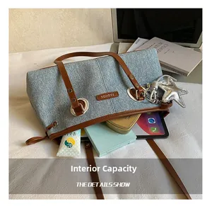 Interior espacioso del bolso tote de mezclilla con tableta, cosméticos y dije de estrella
