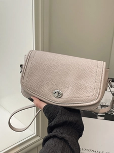 Bolso bandolera de piel beige minimalista francés con hebilla giratoria ovalada plateada
