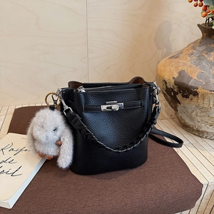 Détails du sac seau en cuir noir grainé avec fermoir argenté et pendentif lapin en peluche