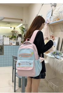 Detail of pink and blue color-block school backpack with cute prints and plush ball