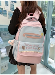 Detail of pink and blue contrast backpack with happy time text and plush pendant charm