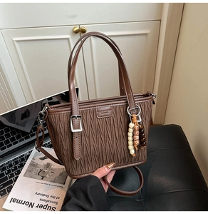 Close-up of brown pleated texture bucket bag with ethnic beads and adjustable strap