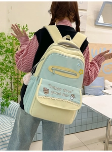 Detail of contrast color school backpack with lace trim and cute cartoon patterns