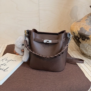 Détail du sac seau en cuir avec poignée tressée et breloque lapin en peluche élégante
