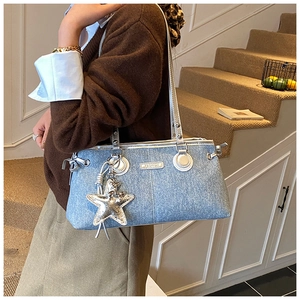 Détail du sac bowling en jean avec breloque étoile argentée et plaque fashion