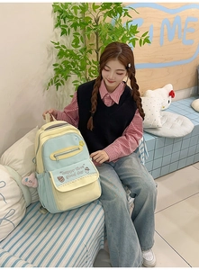 Detail showing macaron color patchwork backpack with happy time print and plush pendant