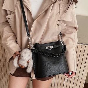 Détail du sac seau en cuir noir grainé avec fermoir rotatif argenté et breloque lapin