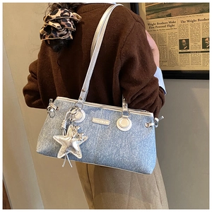 Gros plan du sac à main bleu clair pailleté avec étoile argentée et plaque de mode