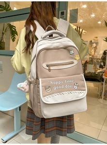 Detailed close-up of a cream canvas backpack with contrast colors and star patches