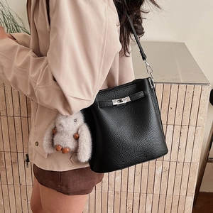 Détail du sac seau en cuir grainé noir avec finitions argentées et charm lapin gris