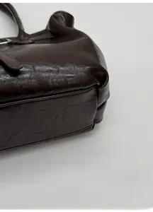 Close-up of the widened base and vintage leather texture of this brown tote bag