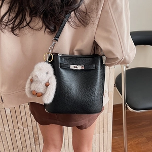 Détail du sac seau en cuir noir avec fermoir tournant argenté et breloque lapin en peluche