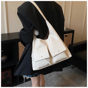 Detail of white PU leather hobo bag featuring two large front flap pockets for extra storage