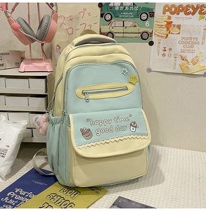 Detail of color-block backpack with multi-pocket storage and cute cartoon pattern
