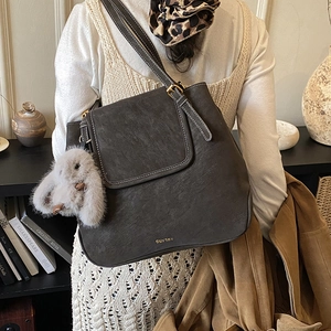 Detail of dark brown tote bag featuring white contrast stitching and plush rabbit charm