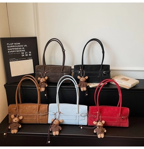 Detailed display of vintage tote bags in five colors with cute bear charms on a shelf