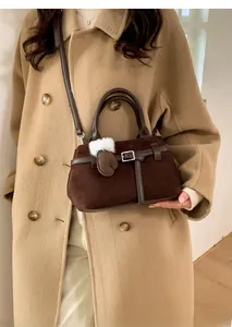 Détails du sac en cuir mat marron foncé avec bandoulière réglable et breloque en peluche