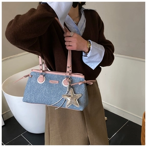 Detalle del bolso bowling de mezclilla con ribetes de cuero rosa y colgante estrella