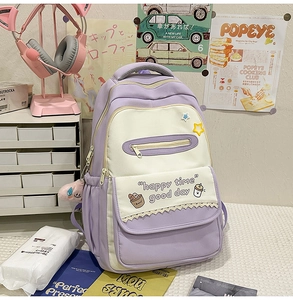 Detail of purple and white school backpack with lace trim and star patch on a desk
