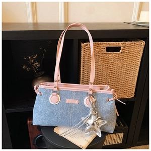 Détail du sac bowling en jean avec finitions en cuir rose et breloque étoile