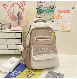 Close-up of brown and beige school backpack with cute embroidery and side water bottle pocket