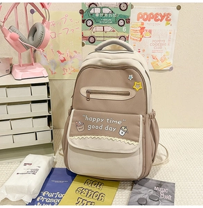 Detail of color-block school backpack with happy time print and multi-pocket design