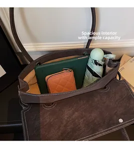 Top view of spacious brown matte leather tote bag interior with tablet and umbrella