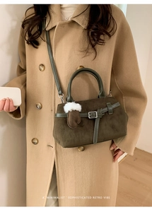 Detail der Retro-Handtasche aus mattem Leder in Olivgrün mit Plüschhandschuh