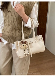 Dettaglio borsa tote retrò beige in finta pelle con ciondolo a forma di orsetto peluche