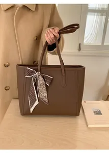 Detail of dark brown lychee pattern leather tote bag with stylish silk scarf decoration