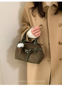 Detail einer dunkelgrünen Wildleder-Einkaufstasche mit Lederband und Handschuh-Anhänger